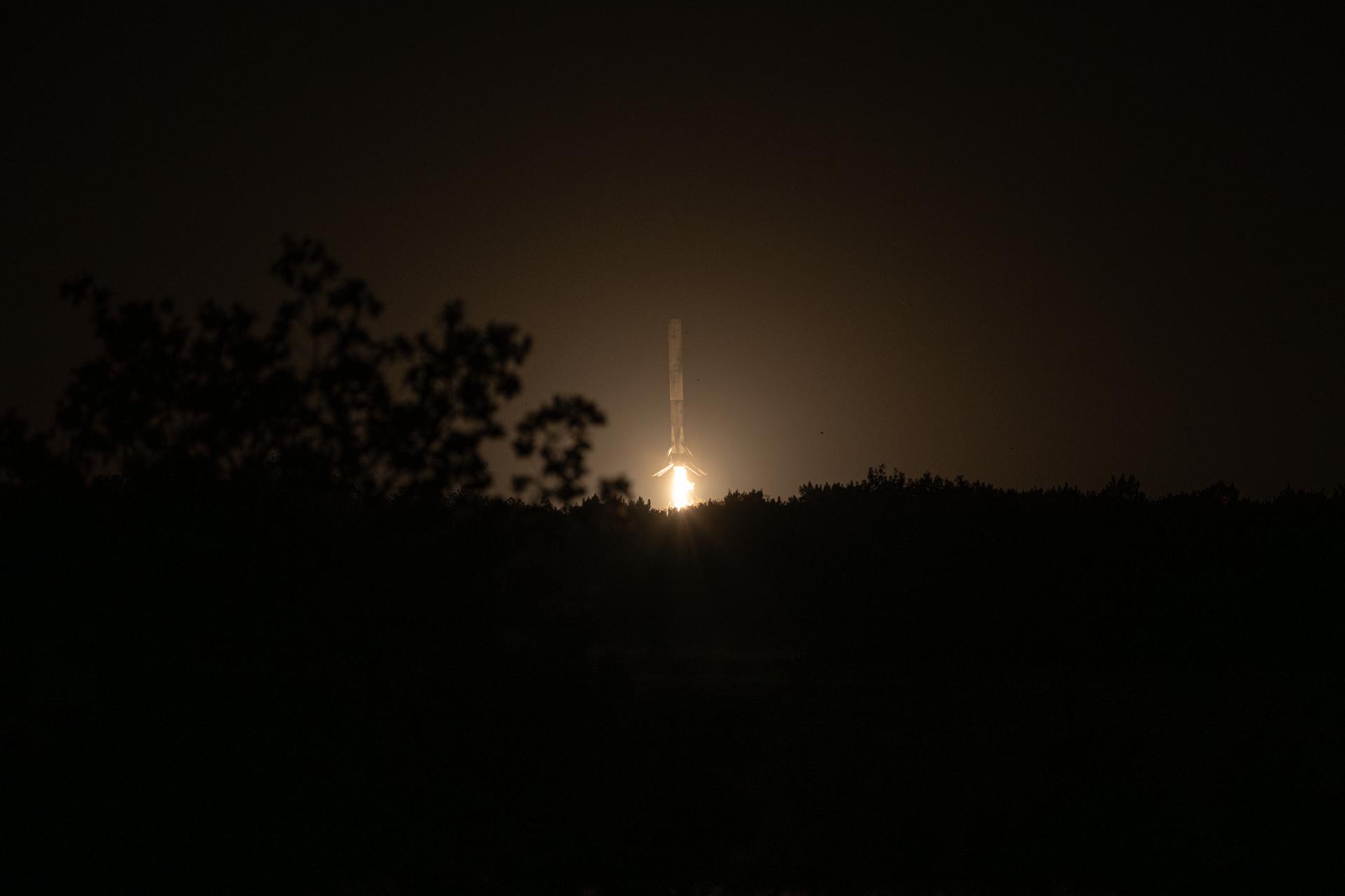 A Falcon 9 first stage descends on its engine to land after a launch