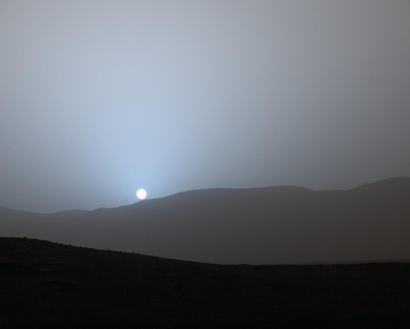 A blue-tinted sunset over the hills of Mars, photographed by the Curiosity rover
