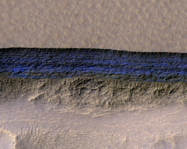 A steep Martian slope where a band of blue-white underground water ice is exposed