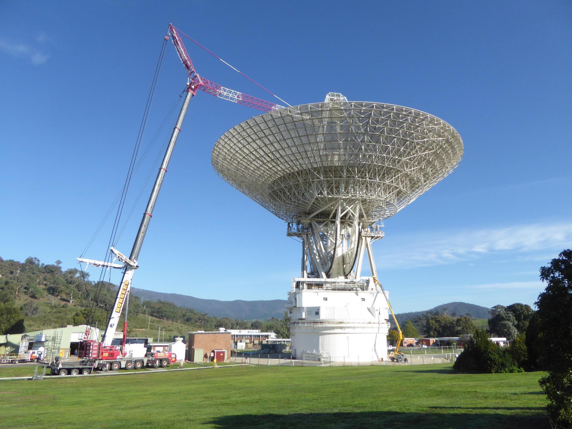 A giant Deep Space Network radio dish antenna against a blue sky